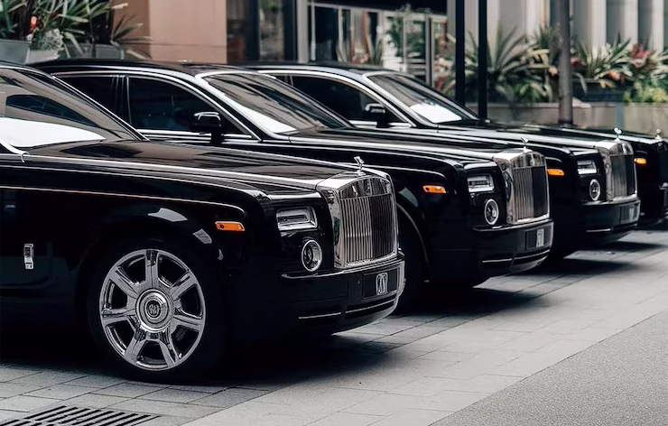 Row of black Rolls-Royce sedans outside a hotel