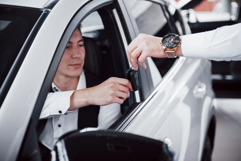 Chauffeur receiving car keys through the driver's window